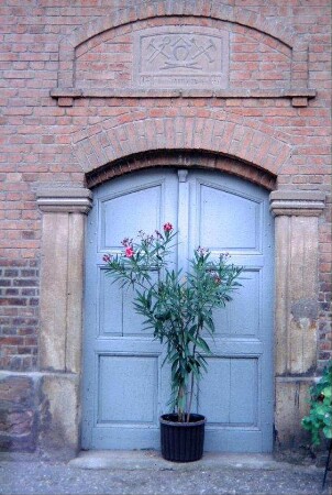 Haustür der alten Schmiede, darüber Innungszeichen