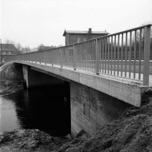Trave: Brückenneubau: Spannbetonbrücke nach Fertigstellung: im Hintergrund Wohn- und Bauernhäuser: hinten rechts Gaststätte "Brückenkrug"