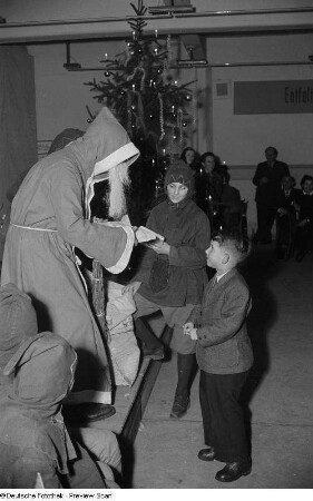 Weihnachtsmann, einem Jungen ein Geschenk überreichend