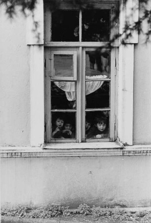 Kinder hinter dem Fenster eines Kindergartens