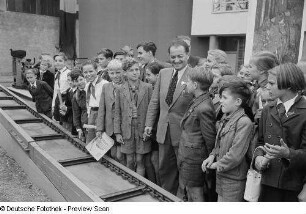 Kinder zu Besuch auf der Leipziger Herbstmesse 1954 an einem Förderband