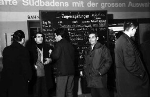 Freiburg: Hauptbahnhof. Italienische "Gastarbeiter" fahren zu Weihnachten nach Hause, vor Zugankündigungstafel