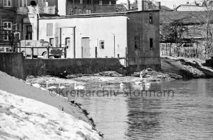 Trave: vorn links Böschung: hinten Nebengebäude und Pkw: dahinter Wohn- und Geschäftshäuser an Hude und Heiliggeist-Viertel: vorn links Böschung mit Schnee: Winter
