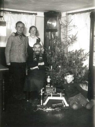 Familie vor Weihnachtsbaum