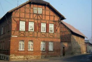 Eckgehöft: Backsteinbau mit Fachwerkobergeschoss, Krüppelwalmdach, Fensterladen