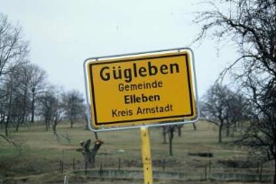 Ortseingangsschild, dahinter Obstwiese
