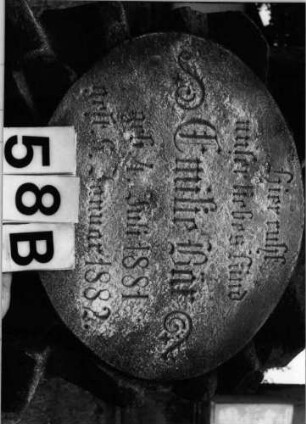 Grabstein 58 (Index: 99804520) Material: Sandstein Zustand: leicht verwittert Maße HxBxT: 86x50x34 cm Beschreibung: rusticaartige Stele, Sockel, ovale Platte Besonderheit: Kindergrab: Grabstein 58B