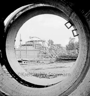 Zentralklärwerk: Bünningstedter Straße: in Bau: Blick durch Betonröhren: hinten Faulturm in Bau, mit Gerüst, Bauzaun