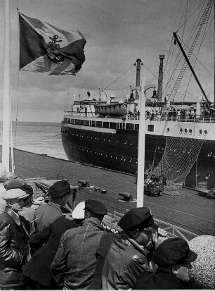 Cuxhaven. Das am 12.03.1927 in Dienst gestellte Passagierschiff "New York" der Hapag liegt am Passagierkai zur Abfahrt nach Amerika bereit. Fracht wird verladen. Interessierte Zuschauer beobachten das Geschehen.