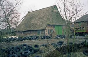 Wassermühlenweg: Fachwerkkate mit Reetdach: Giebelseite Wirtschaftstrakt mit Scheunentor, Traufseite: rechts Wirtschaftsgebäude [angeschnitten]