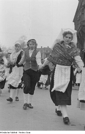 Mehrere verkleidete Frauen gehen Hand in Hand beim Karnevalsfestzug