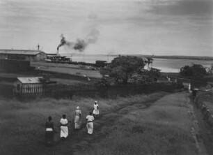 Hafen von Kisumu : Frauen auf einem Feldweg unweit der Anlegestelle im Hafen von Kisumu. Im Hintergrund der Victoriasee