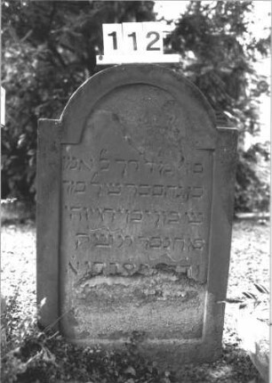 Grabstein 112 (Index: 100114271) Material: Sandstein Zustand: stark abgeblättert mit Textverlust Maße HxBxT: 84x56x7 cm Beschreibung: Stele, Sockel, eingezogener Rundbogenabschluß Besonderheit: Kindergrab: Grabstein 112