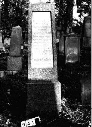 Grabstein 941 (Index: 99802620) Material: Granit mit Marmorplatte Zustand: sehr gut Maße HxBxT: 202x62x49 cm Beschreibung: Sockel, Obelisk mit Inschriftenplatte Besonderheit: Endreim, längerer Text: Grabstein 941