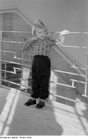 Ein Mädchen präsentiert Kinderbekleidung