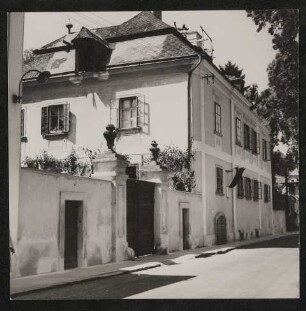 Hofmannsthals Haus in Rodaun, Außenansicht des Eingangstors und des Haupthauses von der Straße mit Beschriftung von Paul Celan