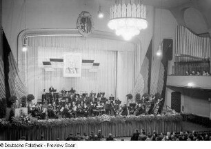 Redner und Orchester auf der Bühne
