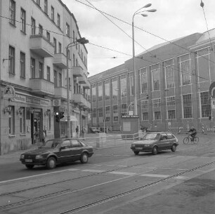 Berlin-Schöneweide, Wilhelminenhofstraße 16/16A/17/Ecke Edisonstraße. Wohnblock mit Läden und Gaststätte (nach 1994 saniert). Blick nach Süden gegen Maschinenhalle (1898/1899, P. Tropp) des Transformatorenwerk Oberschöneweide (Teilansicht)