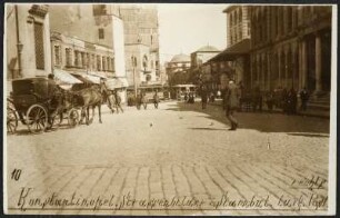 Belebter Straßenzug in Istanbul mit Passanten, Pferdekutsche, im Hintergrund Straßenbahn sowie Moschee, rechts im Bild Post-Gebäude mit Säulenportal