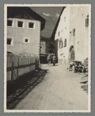Mann mit Pferd in einer Gasse in Zuoz
