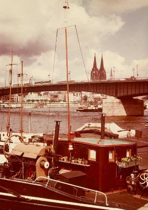 Köln, Blick vom Deutzer Ufer auf Frachtschiff, Deutzer Brücke und linksrheinsiche Altstadtseite