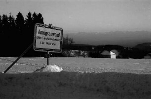 Amrigschwand: Ortsschild Amrigschwand; Hintergrund Alpenkette (matt)