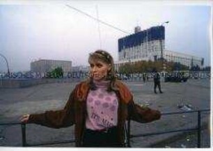 Junge Frau vor dem beschädigten "Weißen Haus" in Moskau