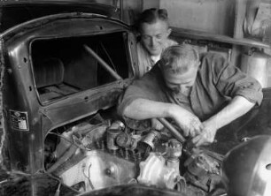 Autoschlosser : Portrait von zwei Mechanikern bei der Arbeit an einem Automobil (Opel)