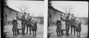 Eine Familie auf einem Hof, umrundet von mehreren Bauernhäusern