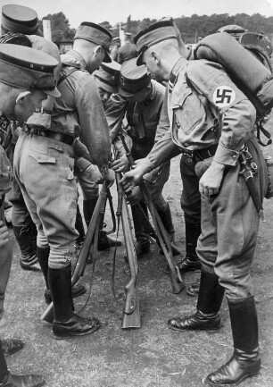Ein Sturm der Hamburger SA mit voller Ausrüstung bei einer militärischen Ausbildung. Eine Gewehrpyramide wird gesetzt.