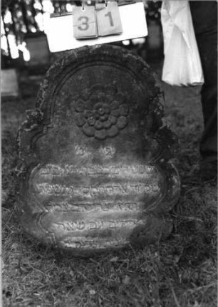 Grabstein 31 (Index: 99796032) Maße HxBxT: 82x58x9 cm Symbolik: Blüte Besonderheit: kulturhistorisch wertvoll / künstl.-formale Gründe (Steingestaltung): Grabstein 31