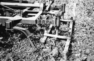 Elektrisch angetriebene Rüttelegge hinter Federzahngrubber am Unimog