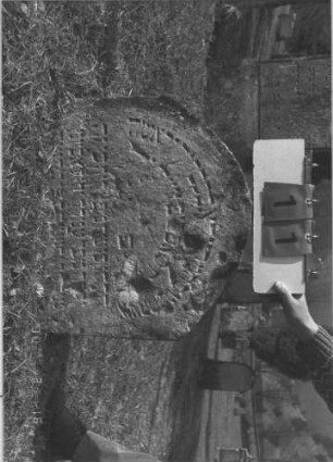 Grabstein 11 (Index: 100009459) Zustand: zur Hälfte eingesunken, zum Teil abgebröckelt Maße HxBxT: 54x60x11 cm: Grabstein 11