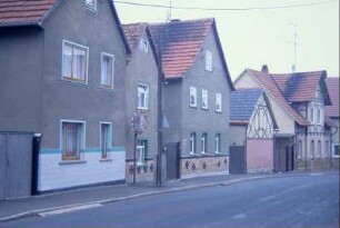 Straßenzug mit einer Reihe giebelständiger Wohnhäuser, kleine Hoftore