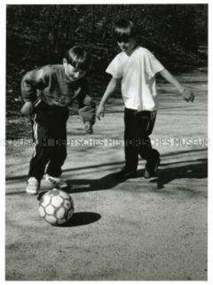 Zwei Jungen spielen Fußball (Altersgruppe bis 14)