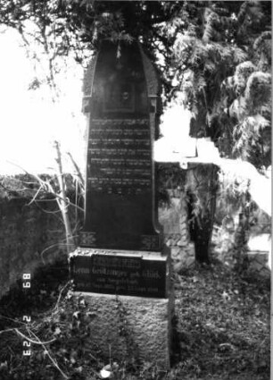 Grabstein 29 (Index: 99751734) Material: Granit Zustand: gut Maße HxBxT: 208x61x31 cm Beschreibung: Stele, getreppter Sockel, rund eingezogener obeliskenartiger Abschluß Symbolik: aufgeschlagenes Buch, Mohnkapseln, Stern Steinmetz: Hochadel Grombach: Grabstein 29