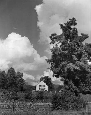 Wolkenbilder. Wohnhaus mit Garten (wahrscheinlich in Kärnten)