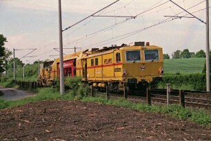 Im Seybeck: Bahnübergang mit gelbem Schienenfahrzeug