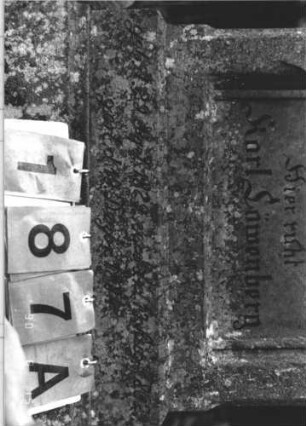 Grabstein 187 (Index: 100106285) Material: Sandstein Zustand: leicht verwittert, teilweise abgeblättert, teilweise Textverlust, Mittelaufsatz fehlt Maße HxBxT: 130x66x19 cm Beschreibung: Stele mit Walmdach und Zinnenvorsatz, Mittelaufsatz fehlt, Schriftfeld eingetieft mit Schulterbogenabschluß, getreppter Sockel Symbolik: floral: Grabstein 187A