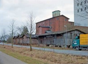 Lasbek-Barkhorst: Mühlenweg 3: Barkhorster Mühle W. F. Stoltenberg: links Bahn-Verladeschuppen der Mühle, rechts Holzschuppen mit altem Schild "Spar - Dahlehnskasse Pölitz", Lkw: dahinter altes Silogebäude aus Backstein: hinten rechts modernes Silo: 26. Januar 1999