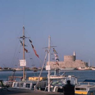 Rhodos (Stadt). Fort Agios Nikolaos, Mandraki-Hafen. Fort Agios Nikolaos v. 1464 und 1480. Mietboote mit dreisprachigem Schild