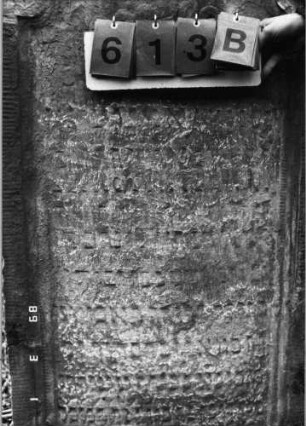 Grabstein 613 (Index: 99753133) Material: Sandstein Zustand: stark verwittert mit großem Textverlust Maße HxBxT: 123x69x10 cm Beschreibung: Stele, geschwungener Abschluß, Schriftfeld eingetieft Symbolik: Muschel: Grabstein 613B