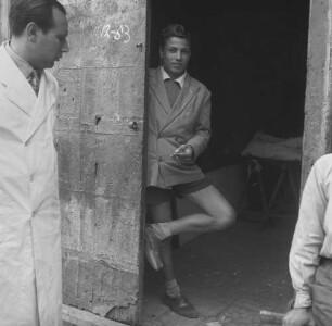 Sizilien, Madonie, junger Mann in kurzen Hosen in einer geöffneten Tür stehend in einem Ort in der Madonie