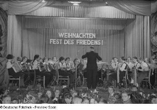 Orchester und Dirigent auf der Bühne bei der Weihnachtsfeier des VEB Bodenbearbeitungsgeräte