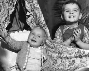 Kinderbilder. Kleiner Junge am Himmelbett eines Geschwisterkindes