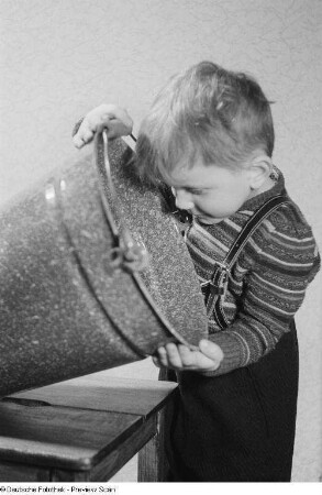 Ein Kind schaut in einen Eimer