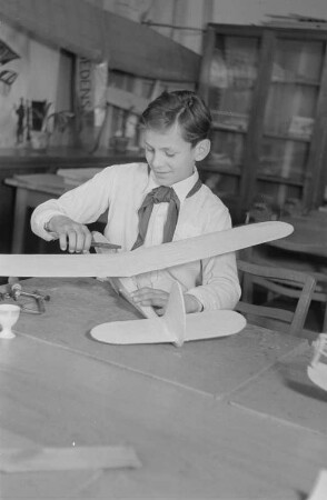 Haus der Kinder: Junge Pioniere beim Segelflugzeugbau und an einer Bohrmaschine : Pionier bei der Konstruktion eines Modellflugzeugs