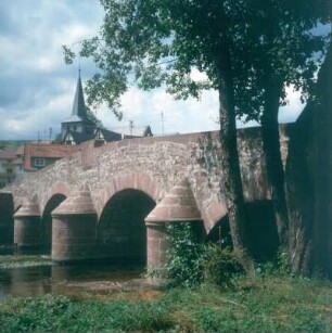 Altengronau. Alte Bogenbrücke über die Sinn. Blick zum Turm der Christi-Himmelfahrt-Kirche