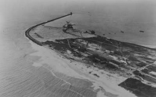 Wellenbrecher : Blick auf eine Hafenanlage am Meer mit einem Wellenbrecher