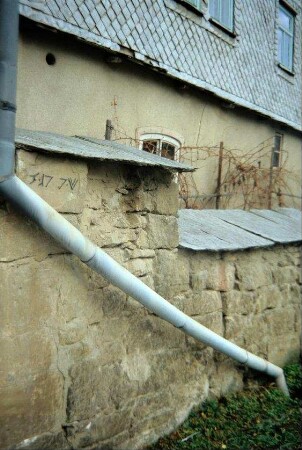 Schiefergedeckte Mauer mit Inschrift